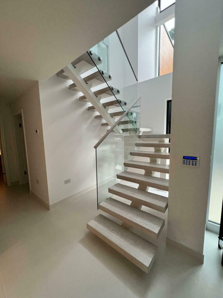 White floating stairs with clear glass panel guardrails